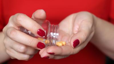 Een mevrouw neemt haar medicijnen in