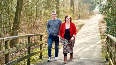 Irene en Jorn lopen over een pad in een bosrijke omgeving. 