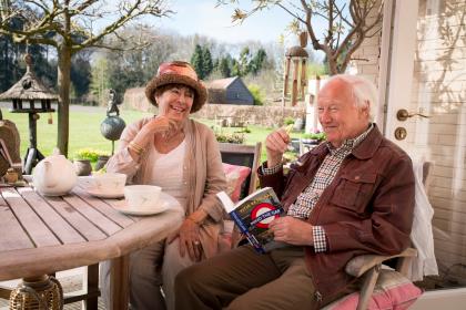 Ouder echtpaar in de tuin op het terras