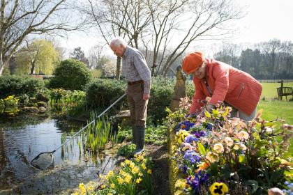 Ouder echtpaar aan het werk in de tuin